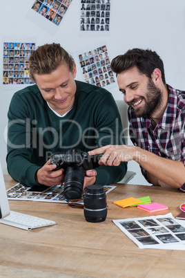 Photographers reviewing captured photos in digital camera