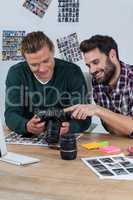 Photographers reviewing captured photos in digital camera