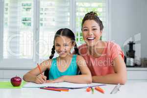 Mother assisting her daughter in doing her homework at home
