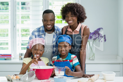 Parents and kids preparing food in kitchen at home