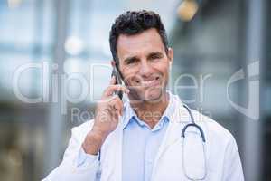 Portrait of smiling doctor talking on mobile phone