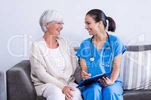 Doctor and senior woman discussing on clipboard
