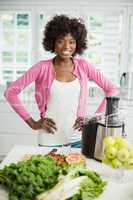 Smiling woman standing with hand on hip in kitchen