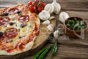 Various species with pizza and tomato on a wooden tray