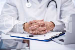 Mid section of doctor sitting at desk