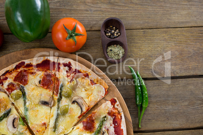 Italian pizza served in a pizza tray with ingredients and vegetables
