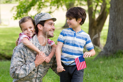 Happy soldier reunited with his son and daughter in park