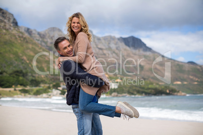 Mature man holding mature woman on beach