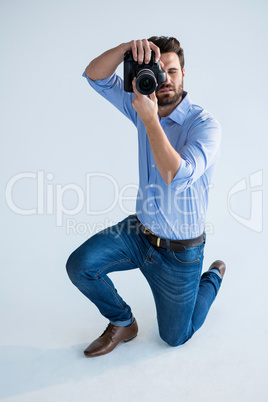 Male photographer with digital camera in studio