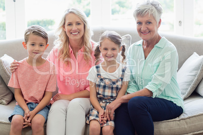 Grandmother with mother, son and daughter relaxing on sofa