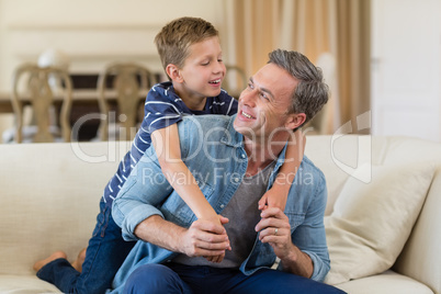 Smiling son embracing a father in living room