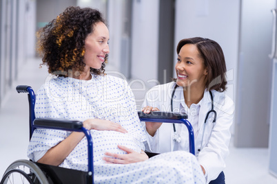 Doctor comforting pregnant woman in corridor