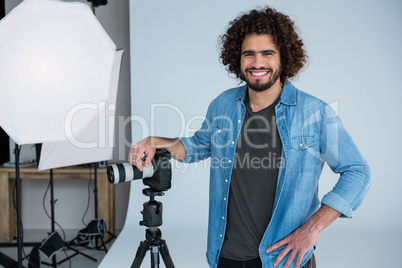 Happy male photographer standing in studio