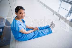 Portrait of smiling nurse sitting on floor