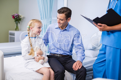 Sick girl and father in hospital bed