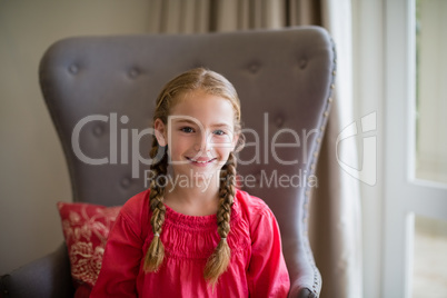 Portrait of smiling cute girl sitting on chair