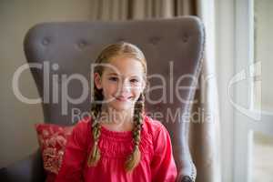 Portrait of smiling cute girl sitting on chair