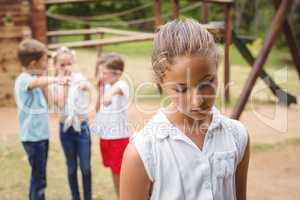 Upset girl with friends gossiping in background