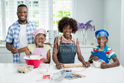 Parents and kids preparing food in kitchen at home