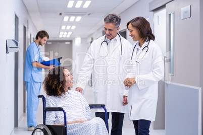 Doctors interacting with pregnant woman in corridor