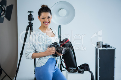 Happy female photographer standing in studio