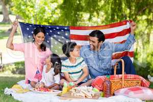 Happy family holding a american flag in park