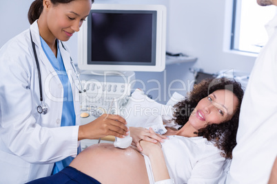 Doctor doing ultrasound scan for pregnant woman