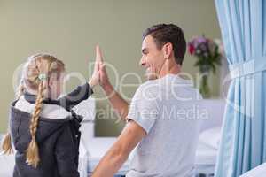 Daughter giving high five to her sick father