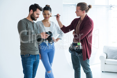 Photographers and female model looking at images on the camera display