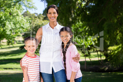 Portrait of mother standing with her kids in park