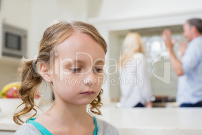 Sad girl listening to her parents arguing