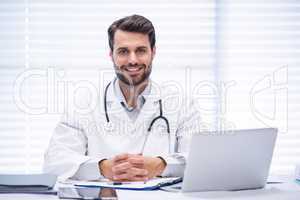 Portrait of male doctor sitting at desk