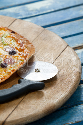 Italian pizza served on pizza tray with cutter