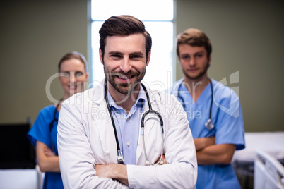 Portrait of male doctor and his colleague standing with arms crossed