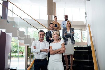 Business executives with arms crossed at conference center