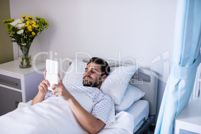 Male patient using digital tablet in the ward