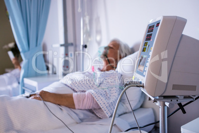 Vital signs monitor with senior patient relaxing in the background