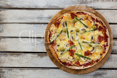 Italian pizza in a chopping board on a wooden plank