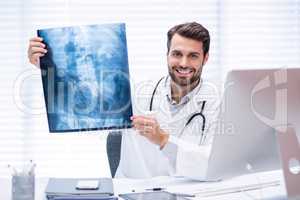 Portrait of male doctor examining x-ray