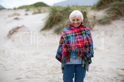 Portrait of senior woman wrapped in shawl on the beach