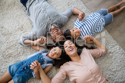 Portrait of happy parents and kids lying on rug