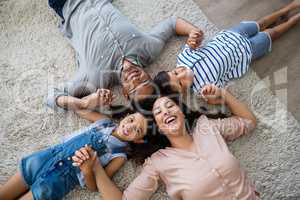 Portrait of happy parents and kids lying on rug