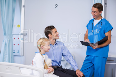 Doctor interacting with sick girl and man