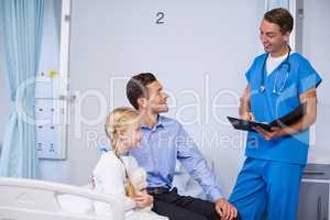 Doctor interacting with sick girl and man