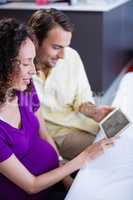 Couple looking at babies ultrasound scan on digital tablet