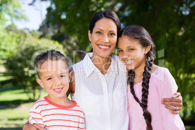 Portrait of mother standing with her kids in park