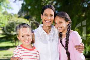 Portrait of mother standing with her kids in park