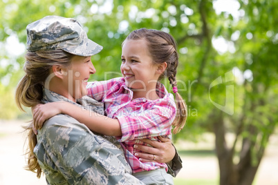 Happy female soldier with her daughter in park