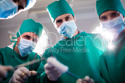 Portrait of medical team holding medical equipment in a operating room