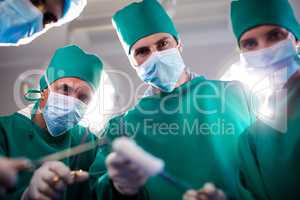 Portrait of medical team holding medical equipment in a operating room